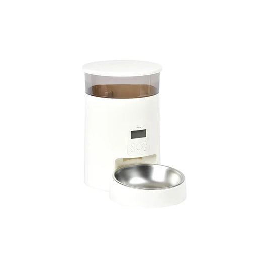 A white automatic pet feeder with a clear upper container showing brown contents, a small digital display, and a matching white base holding a stainless steel bowl, isolated on a white background.